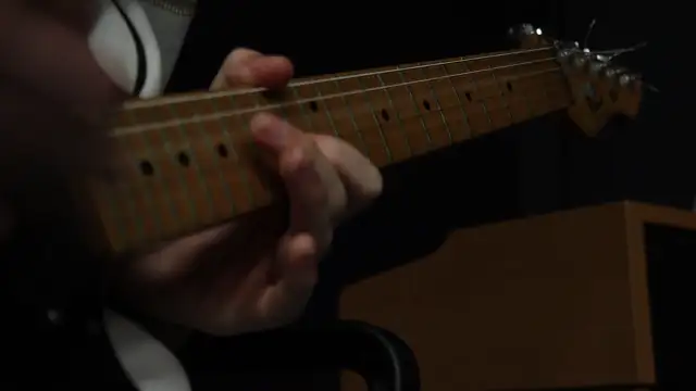 ADOLESCENT WALKING INTO ROOM PICKING UP AND PLAYING A GUITAR THAN WALKING OUT AGAIN