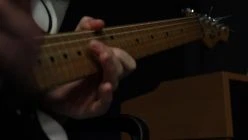 ADOLESCENT WALKING INTO ROOM PICKING UP AND PLAYING A GUITAR THAN WALKING OUT AGAIN